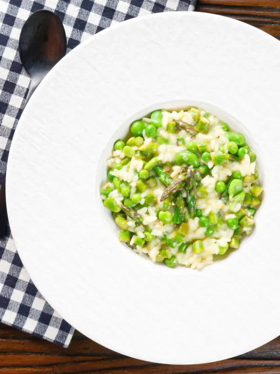 Overhead creamy spring broad bean, pea and asparagus risotto.