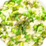 Close-up overhead creamy spring broad bean, pea and asparagus risotto.
