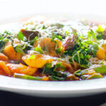Close-up asparagus and tomato orecchiette pasta soup/stew with wild garlic.