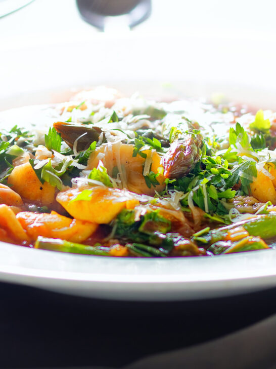 Close-up asparagus and tomato orecchiette pasta soup/stew with wild garlic.