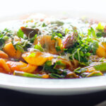 Close-up asparagus and tomato orecchiette pasta soup/stew with wild garlic.