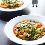 Two bowls of asparagus and tomato orecchiette pasta soup/stew with wild garlic.