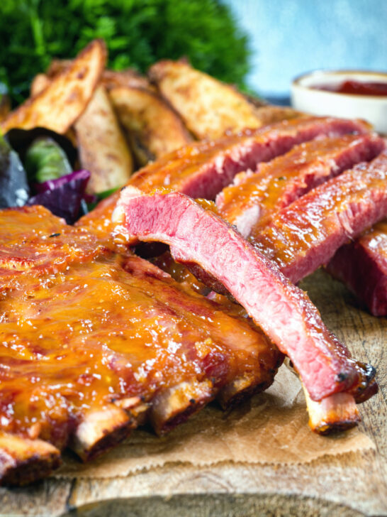 Close-up apricot jam and mustard glazed bacon ribs served with air fryer potato wedges.