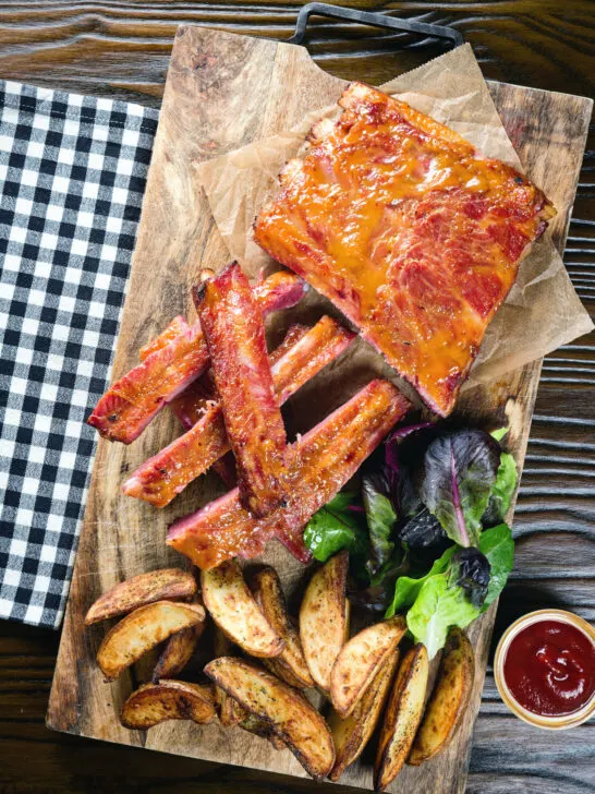Overhead apricot jam and mustard glazed bacon ribs served with air fryer potato wedges.