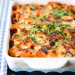 Cheesy baked pasta al forno with a beef, pork and tomato sauce garnished with fresh basil.