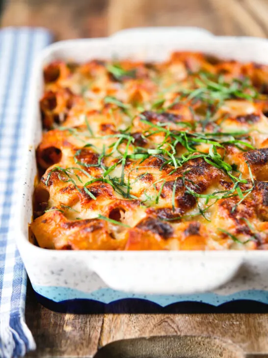 Cheesy baked pasta al forno with a beef, pork and tomato sauce garnished with fresh basil.