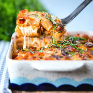 Pasta al forno, cheese topped meaty baked pasta being served from a baking dish.