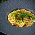 Creamy balsamic leek and mushroom risotto topped with seared leek rings.