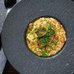 Overhead creamy balsamic leek and mushroom risotto topped with seared leek rings.