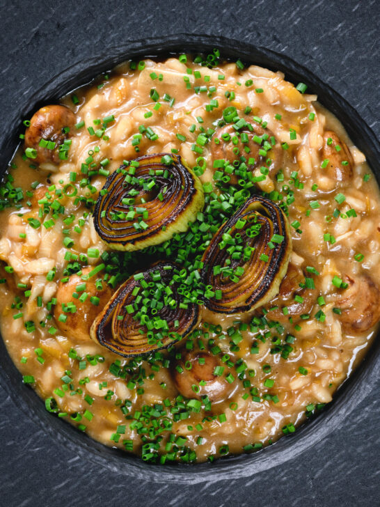 Close-up overhead creamy balsamic leek and mushroom risotto topped with seared leek rings.