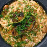 Close-up overhead creamy balsamic leek and mushroom risotto topped with seared leek rings.