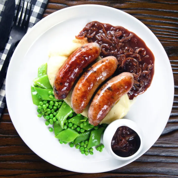 Bangers (sausages) and mash served with onion gravy, peas and runner beans.