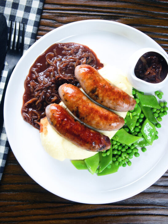 Overhead bangers (sausages) and mash with onion gravy, peas and runner beans.