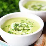 Cream of asparagus soup garnished with snipped chives, served with cheesy bread.