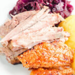 Meat and crackling from a beer roasted pork knuckle, served with potatoes and red cabbage.