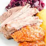 Meat and crackling from a beer roasted pork knuckle, served with potatoes and red cabbage.