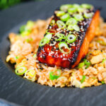 Honey and miso glazed salmon garnished with sesame seeds and spring onion served with egg fried rice.
