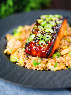 Honey and miso glazed salmon garnished with sesame seeds and spring onion served with egg fried rice.