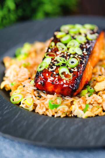 Honey and miso glazed salmon garnished with sesame seeds and spring onion served with egg fried rice.