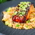 Honey and miso glazed salmon garnished with sesame seeds and spring onion served with egg fried rice.