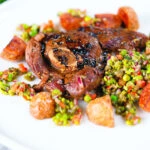 Pan-fried leg of lamb steaks served with pea "salsa" and fried new potatoes.