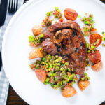 Overhead pan-fried leg of lamb steaks served with pea "salsa" and fried new potatoes.