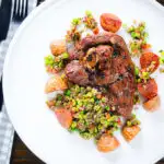 Overhead pan-fried leg of lamb steaks served with pea "salsa" and fried new potatoes.