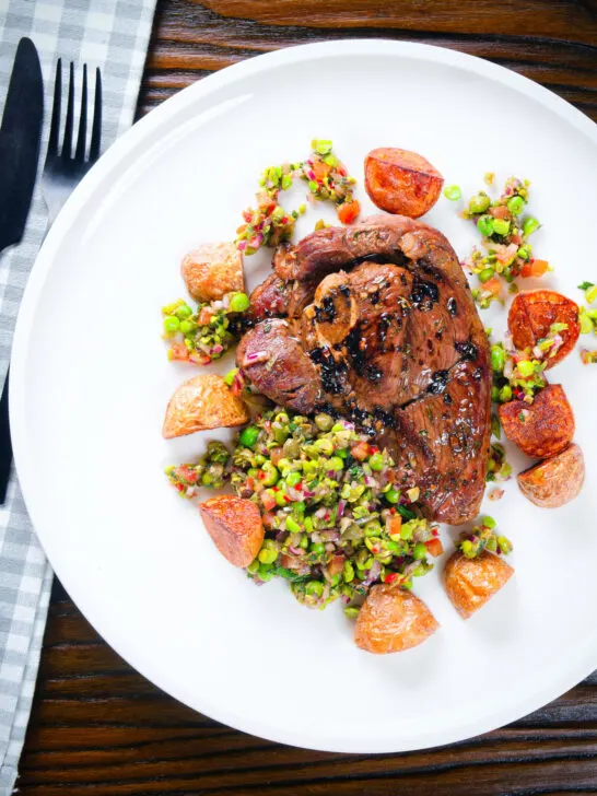 Overhead pan-fried leg of lamb steaks served with pea "salsa" and fried new potatoes.