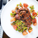 Overhead pan-fried leg of lamb steaks served with pea "salsa" and fried new potatoes.