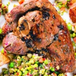 Close-up overhead pan-fried leg of lamb steaks served with pea "salsa" and fried new potatoes.