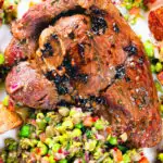 Close-up overhead pan-fried leg of lamb steaks served with pea "salsa" and fried new potatoes.