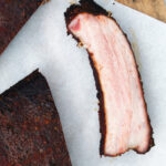 Overhead close-up meaty smoked BBQ pork ribs cut open to show juicy meat texture.
