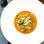 Overhead spicy chicken and prawn soup with Thai influences.