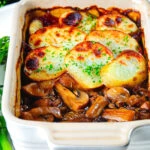 Individual vegan mushroom hotpot topped with potatoes (Lancashire) style showing the filling.
