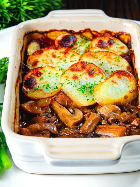 Individual vegan mushroom hotpot topped with potatoes (Lancashire) style showing the filling.