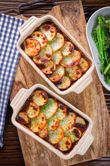 Overhead individual vegan mushroom hotpots topped with potatoes (Lancashire) style.