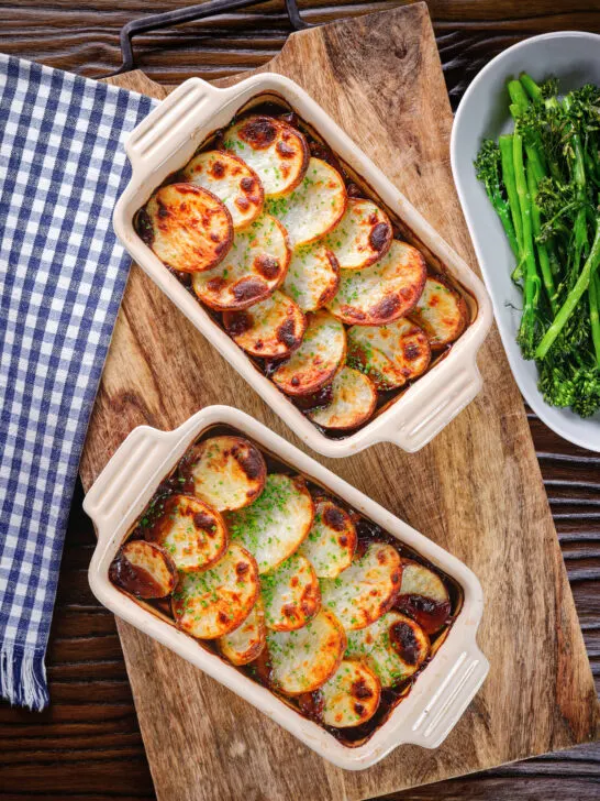 Overhead individual vegan mushroom hotpots topped with potatoes (Lancashire) style.