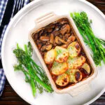 Overhead individual vegan mushroom hotpot topped with potatoes (Lancashire) style (showing filling).