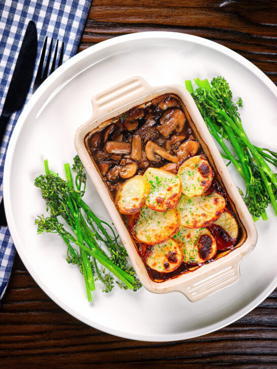 Overhead individual vegan mushroom hotpot topped with potatoes (Lancashire) style (showing filling).