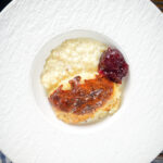 Overhead oven baked British rice pudding served with a dollop of jam.