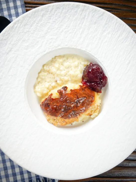 Overhead oven baked British rice pudding served with a dollop of jam.