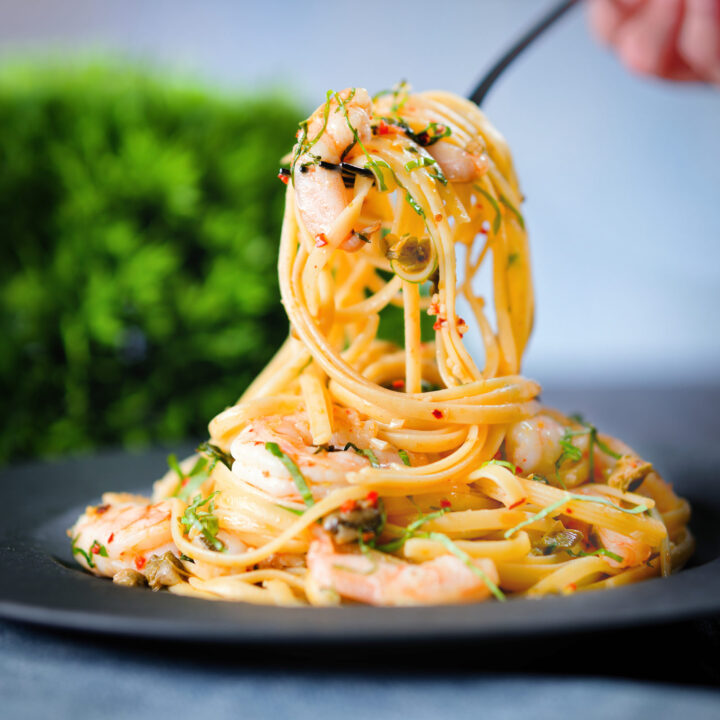 Garlic and chilli prawn linguine with fried capers and basil.