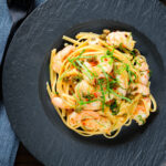 Overhead garlic chilli prawn (shrimp) linguine with fried capers and basil.
