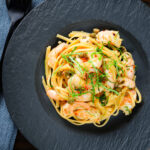 Overhead garlic chilli prawn (shrimp) linguine with fried capers and basil.