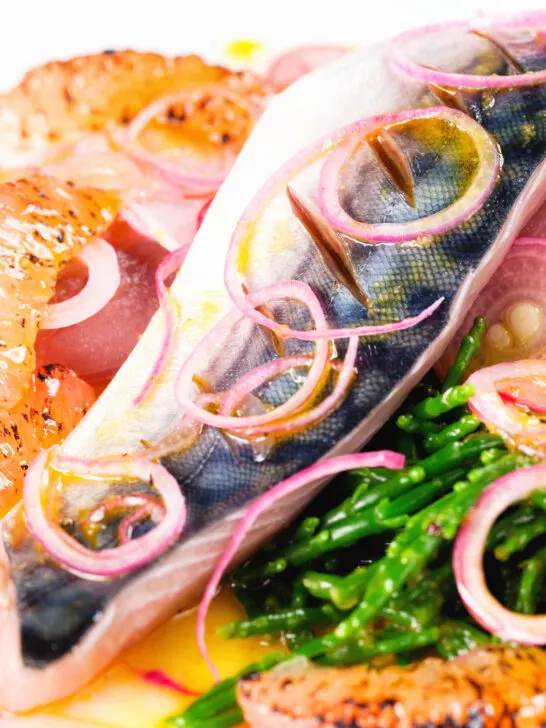 Close-up salt cured mackerel fillet salad with grapefruit, samphire and toasted rye bread.