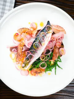 Overhead salt cured mackerel fillet salad with grapefruit, samphire and toasted rye bread.