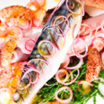 Close-up overhead salt cured mackerel fillet salad with grapefruit, samphire and toasted rye bread.
