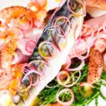 Close-up overhead salt cured mackerel fillet salad with grapefruit, samphire and toasted rye bread.