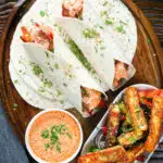 Overhead crispy halloumi cheese wraps with a harissa and yoghurt sauce.