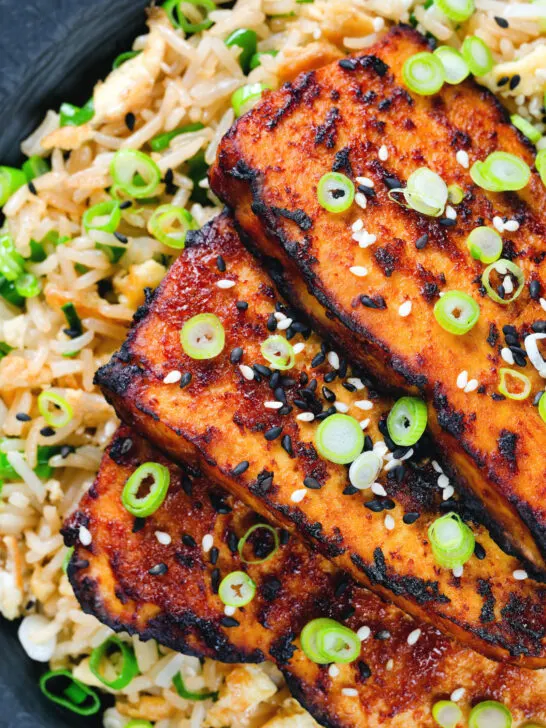 Close-up overhead honey and miso glazed tofu served with egg fried rice.